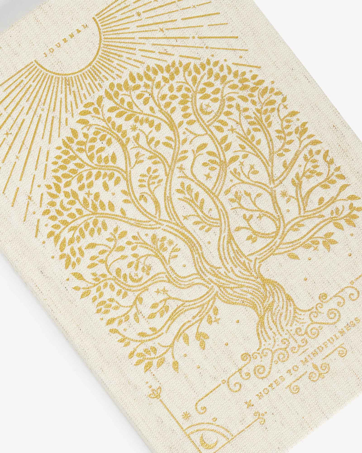 Linen journal cover close-up with gold tree and sunburst line art