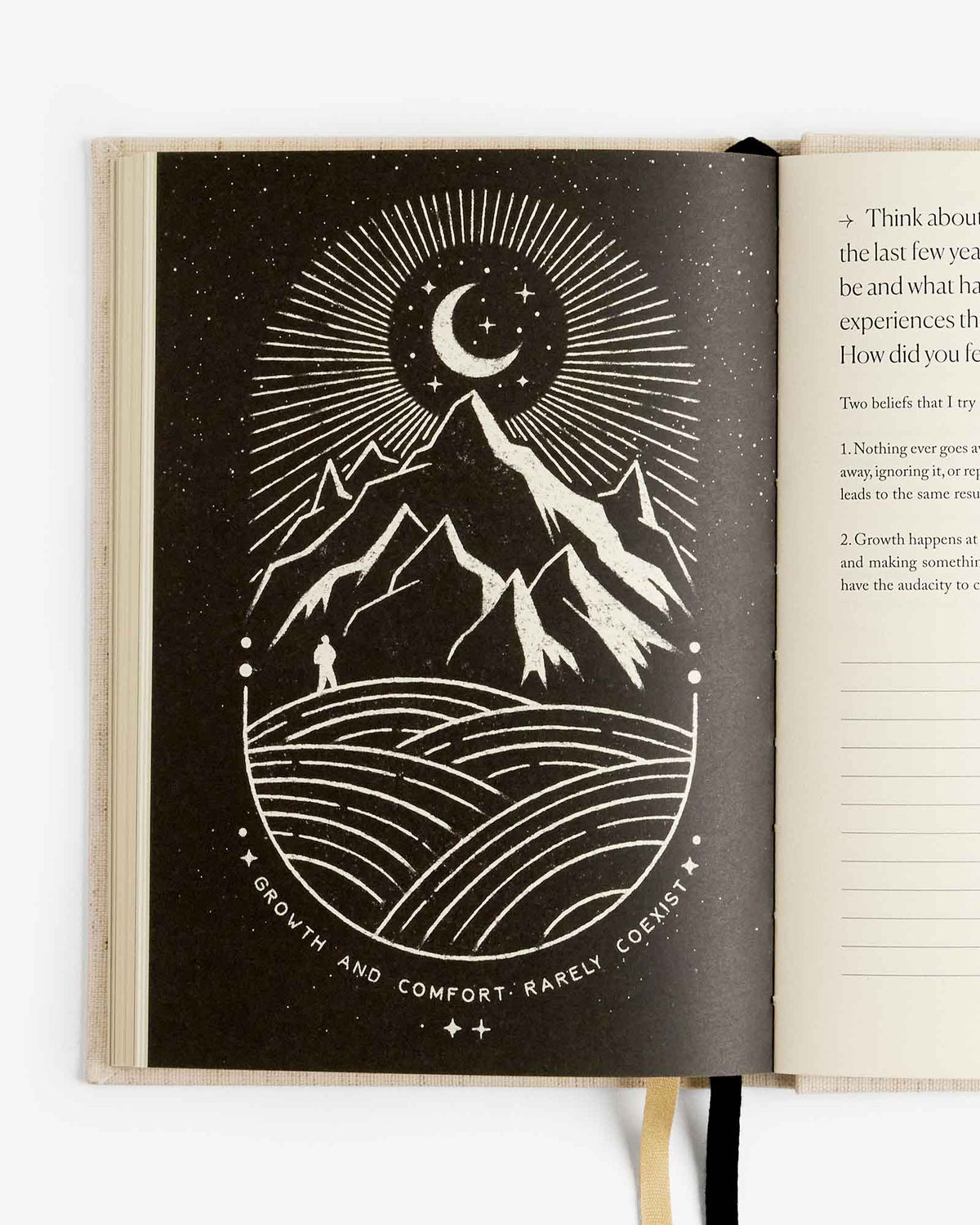 Open journal spread with dark night theme cover art and moon-mountain line drawing