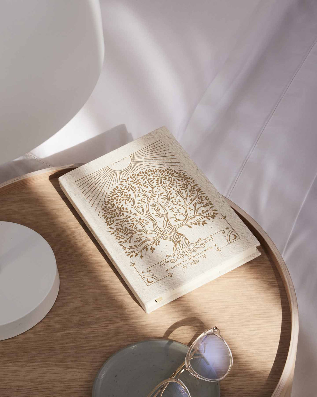 Linen mindfulness journal lying open with gold tree illustration on cream pages