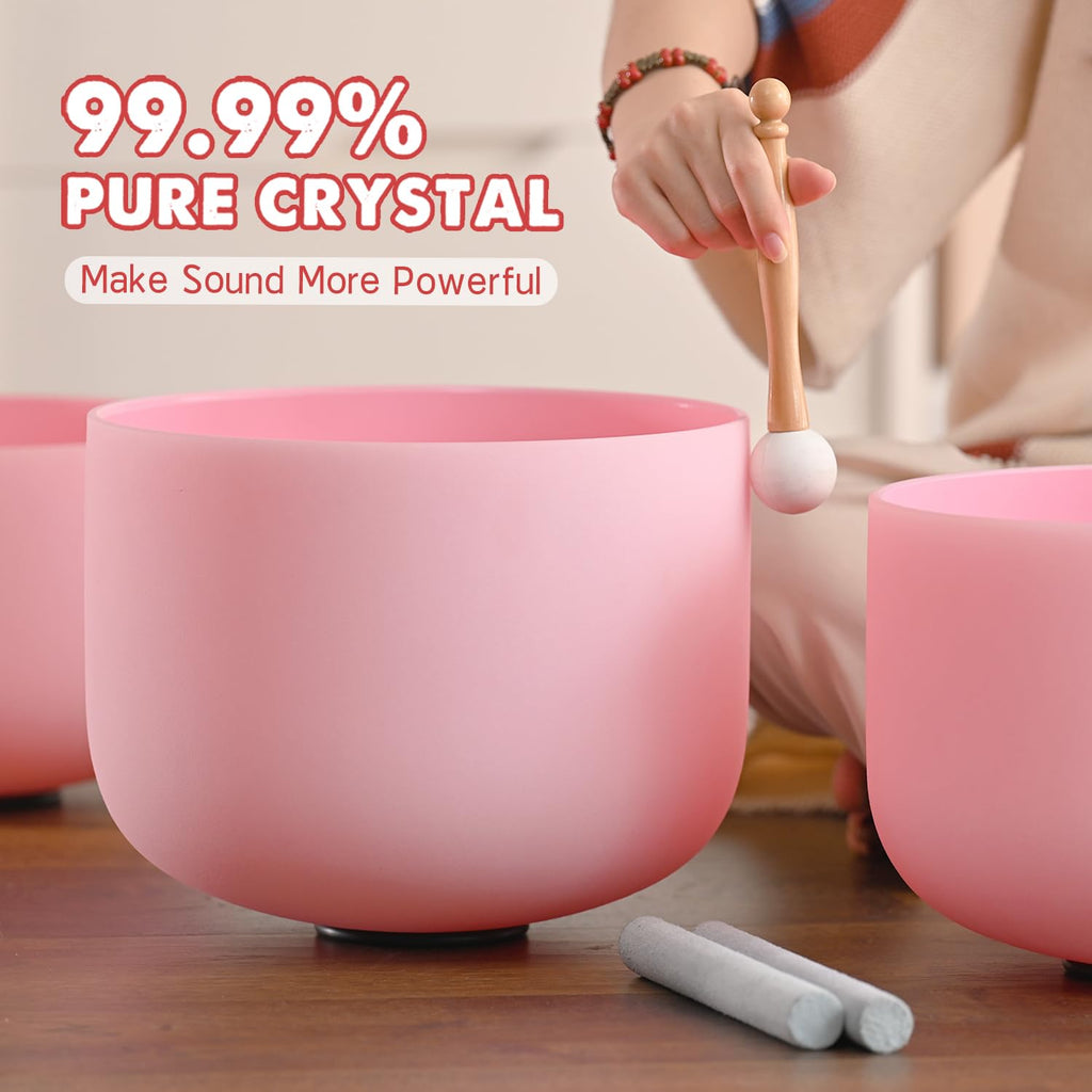 Pink frosted crystal singing bowl being played with a wooden mallet