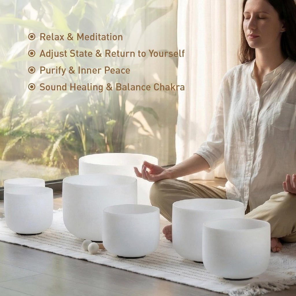 White frosted crystal singing bowls set on a cushion with a seated meditator