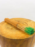 Bamboo skewers with green tips on a wooden surface