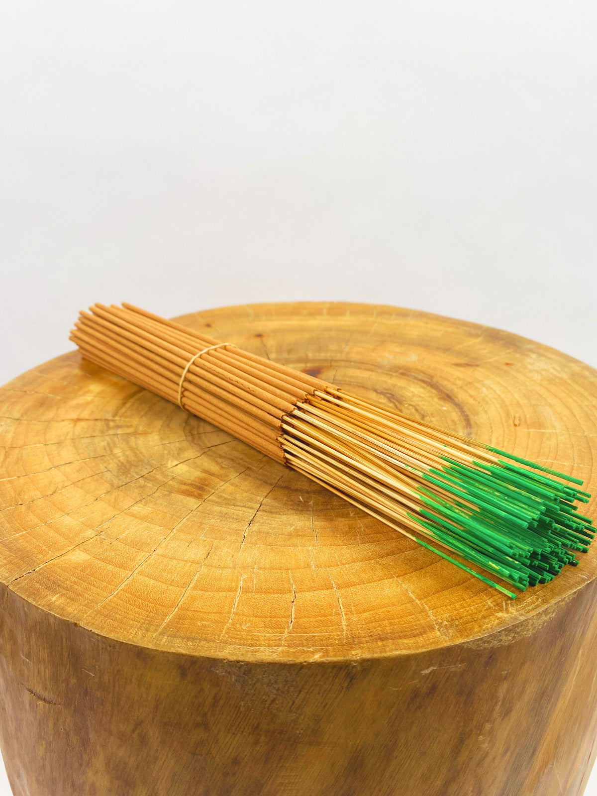 Bamboo skewers with green tips on a wooden surface