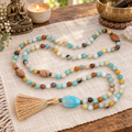 Beaded mala necklace with teal, cream and brown beads, blue teardrop charm, tassel